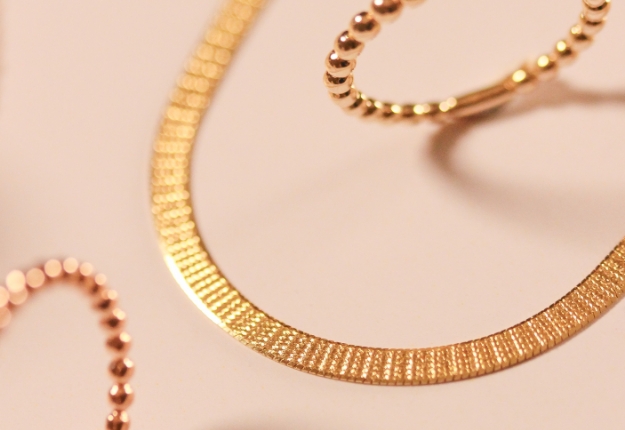 Close-up of solid 14k/18k gold jewelry pieces, showcasing their intricate designs and craftsmanship